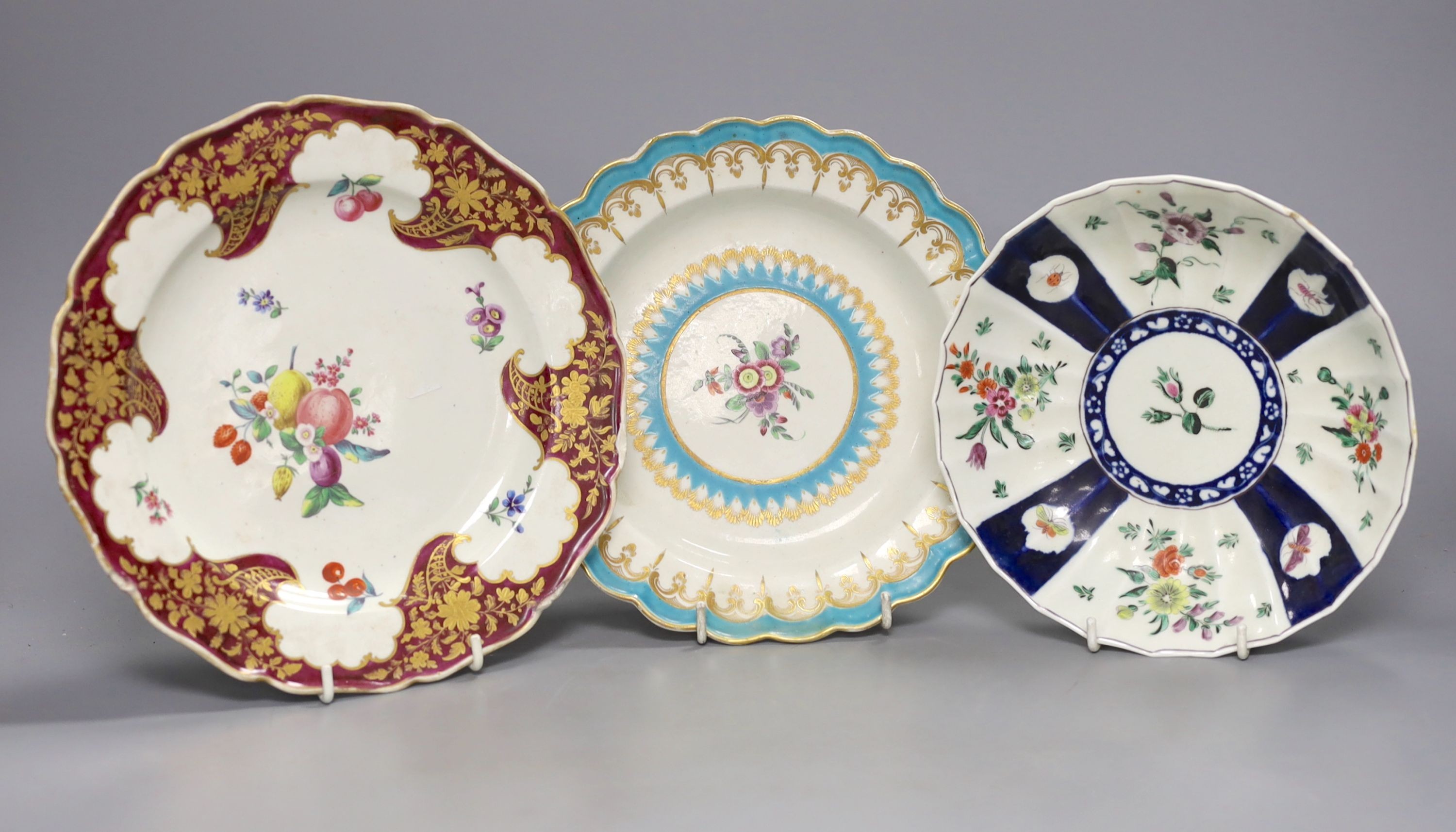 A Worcester plate with two turquoise borders, the centre painted with flowers, a saucer dish with fan shaped panels painted with flowers separated by blue panels and a claret ground plate, turquoise plate 21 cms diameter